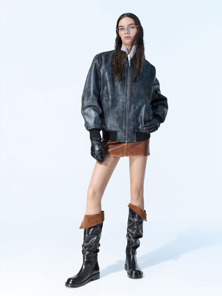 Black knee-high boots with fold-down and buckle details, a timeless and versatile choice for everyday wear.