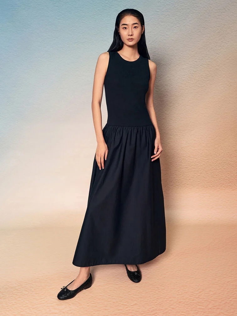 Black ballet flats paired with a black maxi dress creating a continuous visual line. 