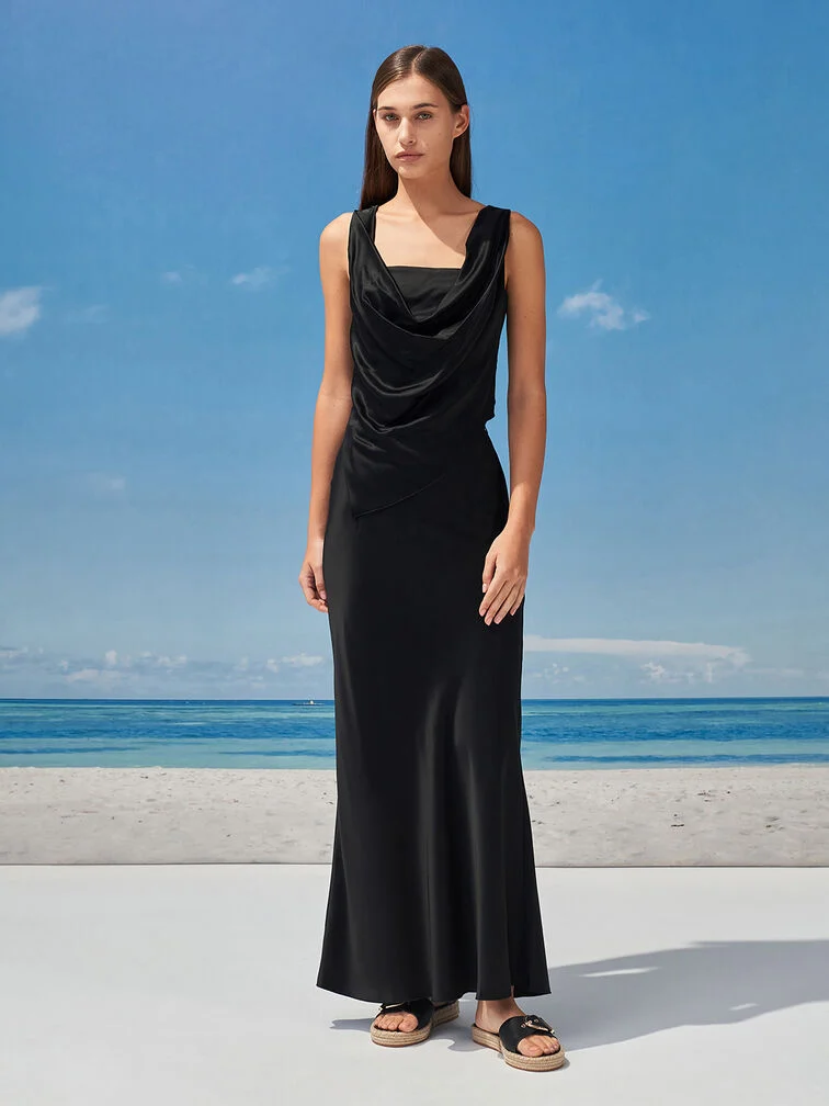 A formal-leaning beach wedding outfit — a black maxi dress paired with espadrille sandals.  