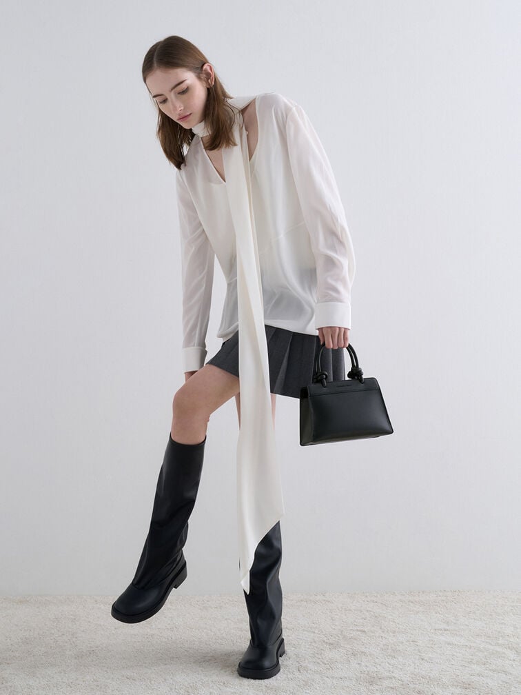 A white blouse, grey pleated skirt, black tote bag and matching knee-high boots.