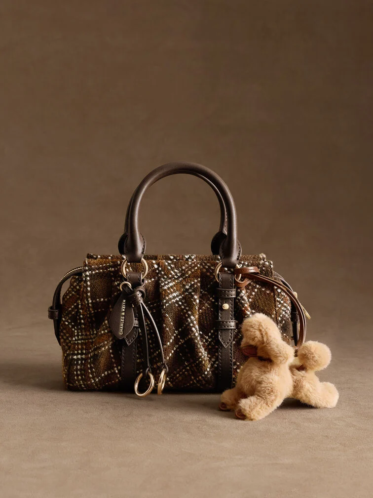 An eye-catching bag charm, such as one in the shape of a furry poodle, will refresh an existing bag and make it feel new again.
