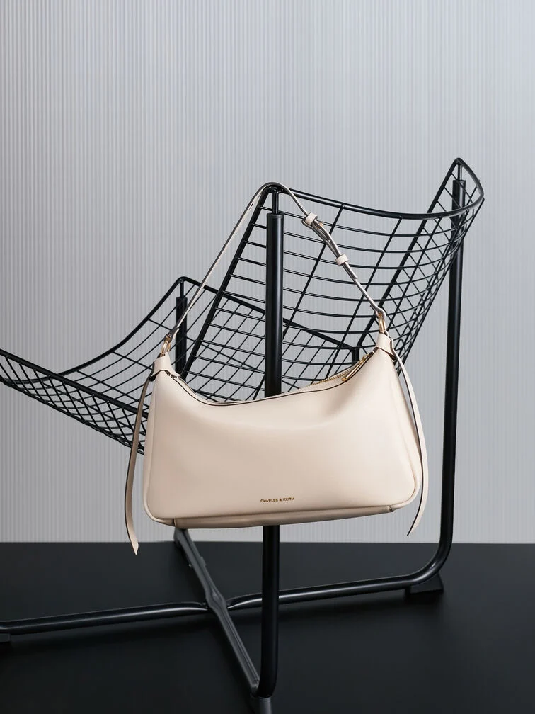 Slouchy shoulder bag in a neutral tone, perfect for a polished yet laid-back look.