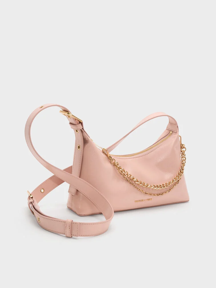 Light pink slouchy shoulder bag with a hanging chain detail, perfect for a sleek, polished look.