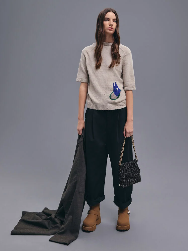 Knitted T-shirt and cuffed pants styled with brown boots and a tweed chain-handle bag.