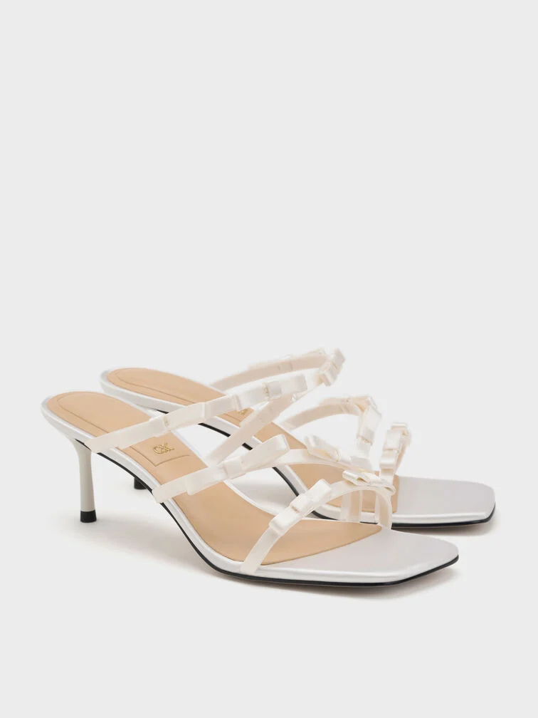 Square-toe heeled sandals with bow straps, ideal for warm-weather celebrations.