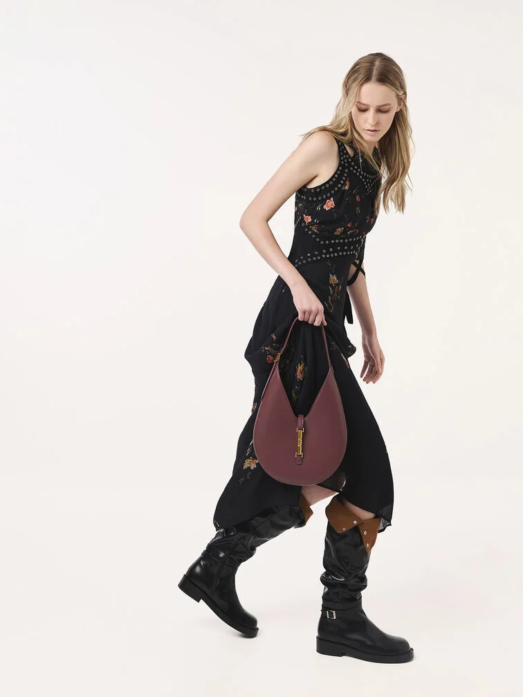 Fold-over boots styled with a floral midi dress and a wineberry-red hobo bag for an elevated boho-chic look.