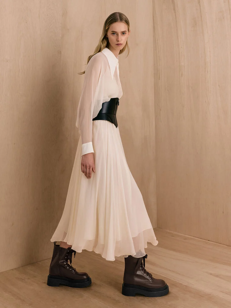 Dark brown platform combat boots styled with a sheer, floaty off-white dress.