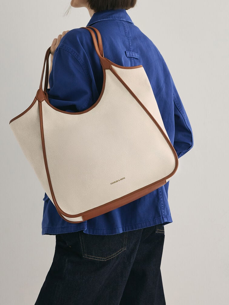 Slouchy canvas tote bag with double handles and contrast trimming.