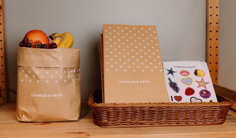 An aesthetic shot of CHARLES & KEITH Kraft paper bags and stickers