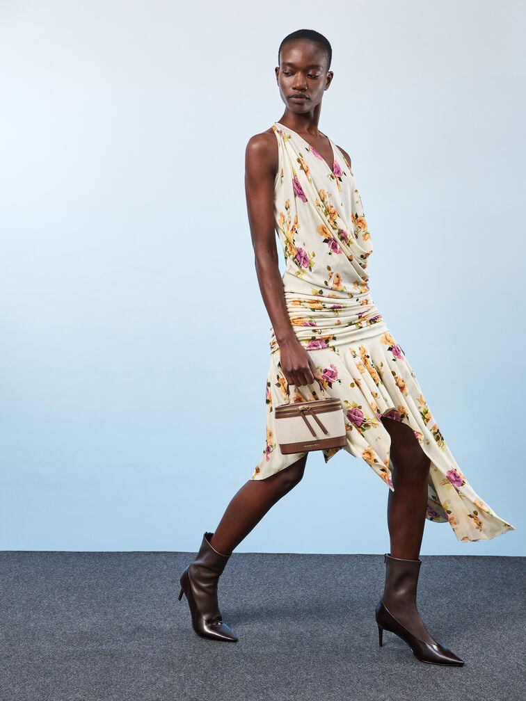 A statement floral dress accessorised with a canvas vanity bag and heeled booties.