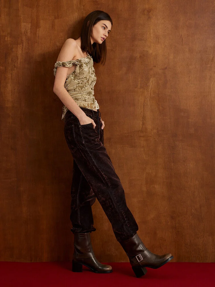 Side-buckle ankle boots styled with matching brown jeans tucked in, a stylish brunch outfit.