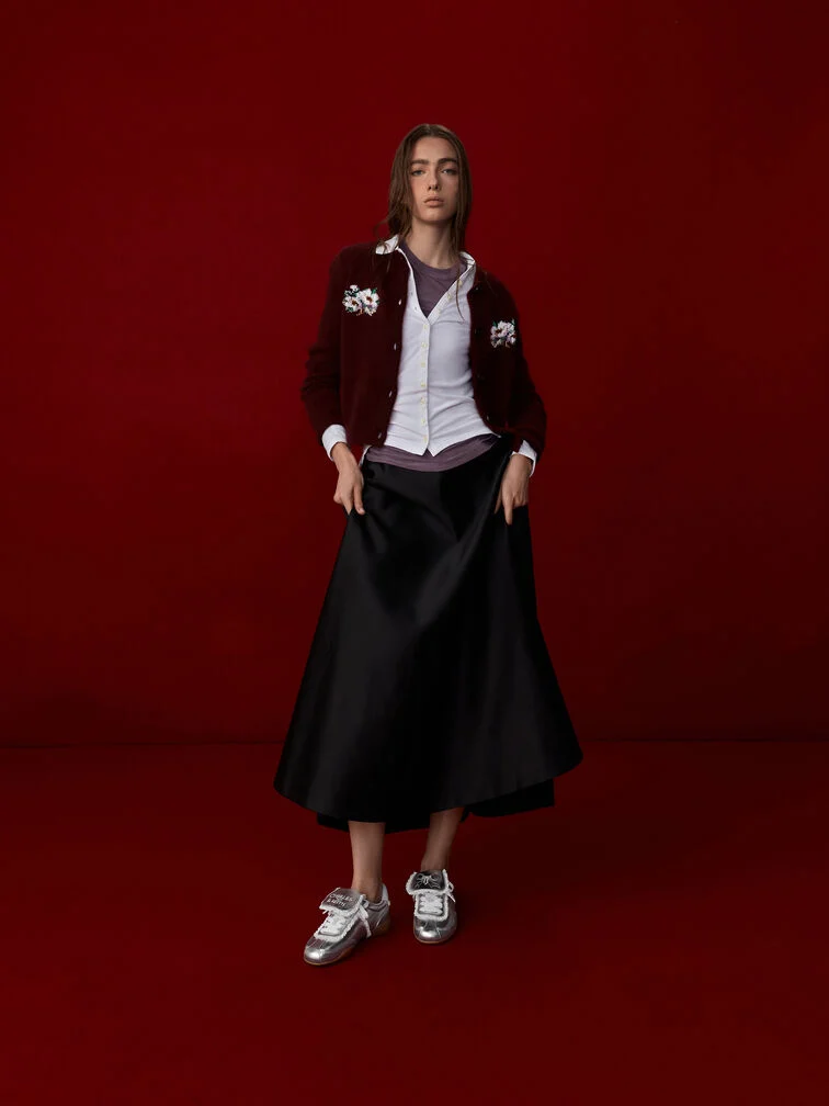Putting together the wide hem of a fluid midi skirt and the sleek almond toes of low-profile sneakers result in flattering, eye-pleasing lower-body proportions. 