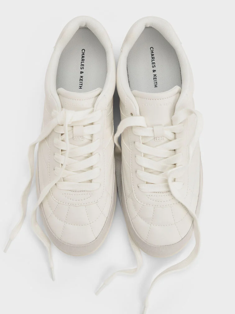 White low-profile sneakers with refined details are a cool, stylish alternative to classic dress shoes for business-casual settings. 
