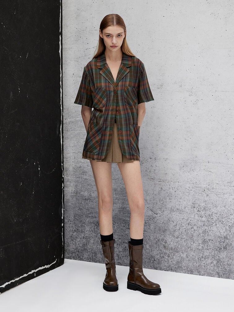 Lug-sole calf boots styled with an earth-toned plaid shirt and caramel pleated skirt.
