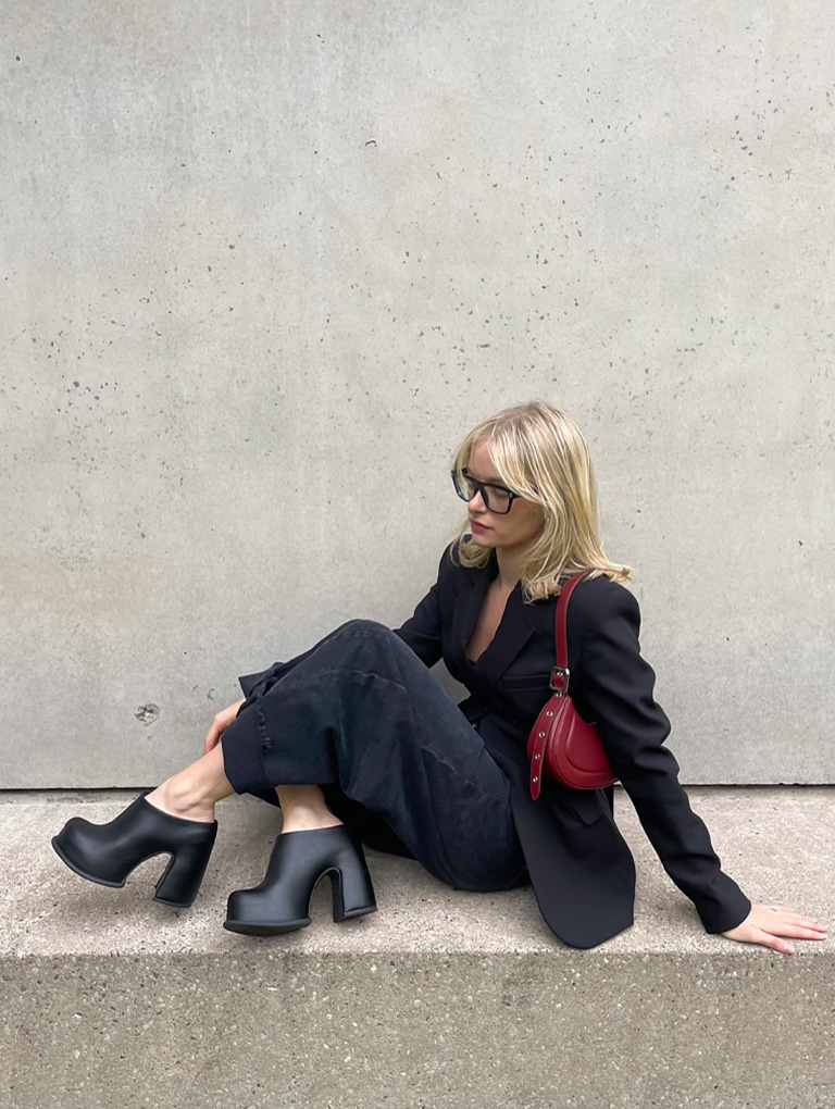 Women’s Petra curved shoulder bag in red and Pixie platform mules in black, as seen on Bridget Brown – CHARLES & KEITH